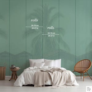 Puede incluir: Escena de dormitorio con una cama con ropa de cama blanca y una manta beige. La pared tiene un mural verde con un dise&ntilde;o de palmera. El texto "rolls" y las medidas de 50-70 cm y 20-27 pulgadas son visibles.