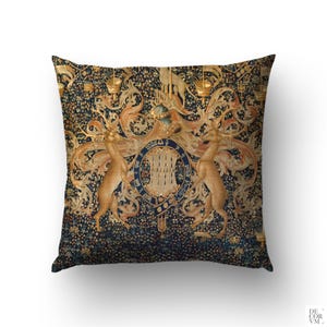 Könnte beinhalten: Ein dekoratives Kissen mit einem Vintage-Tapisserie-Design mit einem Wappen, zwei goldenen Hirschen und komplizierten floralen Mustern auf einem dunkelblauen Hintergrund.