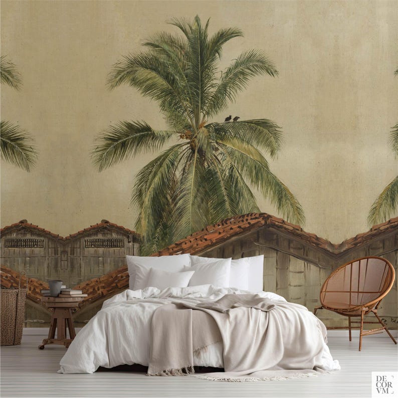 Puede incluir: Un dormitorio con un mural que representa un paisaje tropical con palmeras y tejados. La cama tiene ropa de cama blanca y una manta beige. Tambi&eacute;n se ve una silla de madera y una mesita auxiliar.