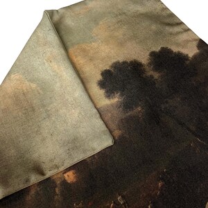 May include: A brown and beige throw pillow with a vintage landscape scene printed on the front. The scene features a group of people in a field with trees in the background.