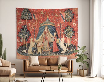 May include: A tapestry depicting a scene from the Unicorn Tapestries. A woman in a blue gown kneels before a unicorn, while a lion watches from the left. The tapestry is set against a red background with a blue and white tent in the center.