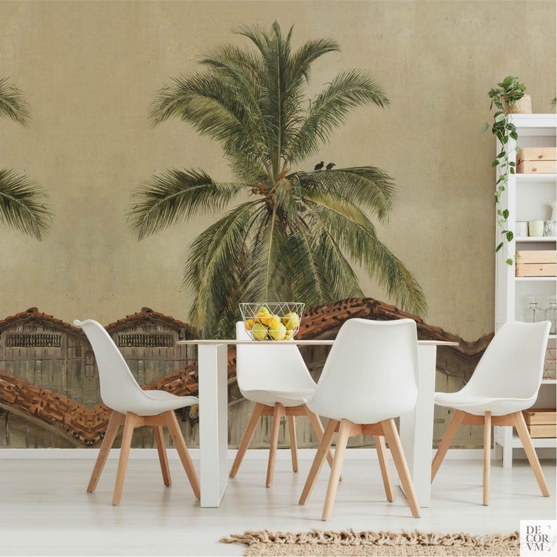 Puede incluir: Un comedor con una mesa blanca y cuatro sillas blancas con patas de madera. Una cesta de alambre con limones est&aacute; sobre la mesa. El tel&oacute;n de fondo es un mural de una palmera y edificios r&uacute;sticos.