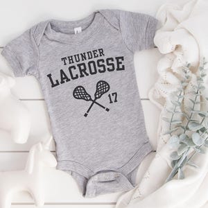 a bodysuit that says thunder lacrosse on it
