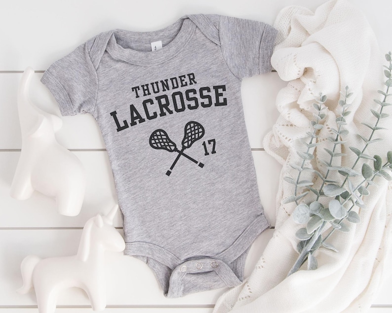 a bodysuit that says thunder lacrosse on it