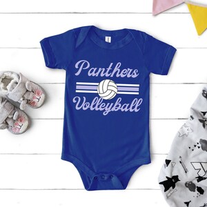 a blue bodysuit with a volleyball on it next to a pair of baby shoes