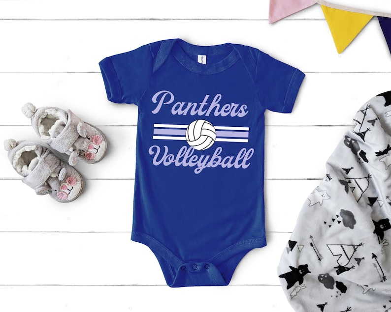 a blue bodysuit with a volleyball on it next to a pair of baby shoes