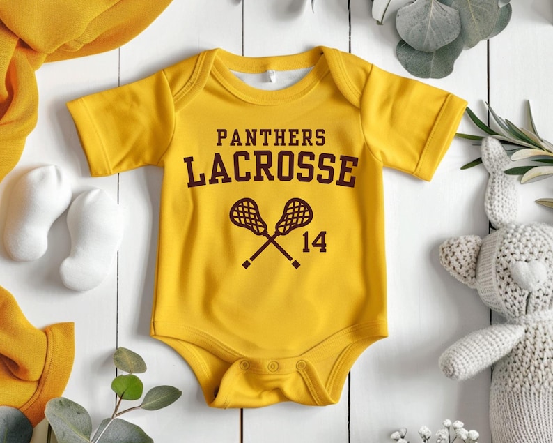 a baby bodysuit with a lacrosse design on it