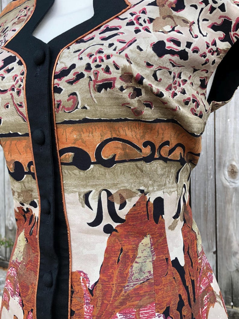 May include: A sleeveless top with a unique pattern in shades of brown, orange, and black. The top features a black trim and buttons down the front. The fabric has a vintage look with an abstract design.