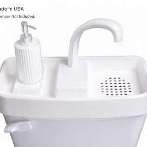 May include: A white toilet tank topper sink featuring a curved faucet, a perforated drain area, and a designated space for a soap dispenser. The unit includes a flush handle on the side. Text on the image reads Made in USA and Soap Dispenser Not Included.