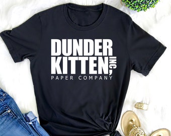 May include: Black t-shirt with white text that reads "Dunder Kitten, Inc. Paper Company"