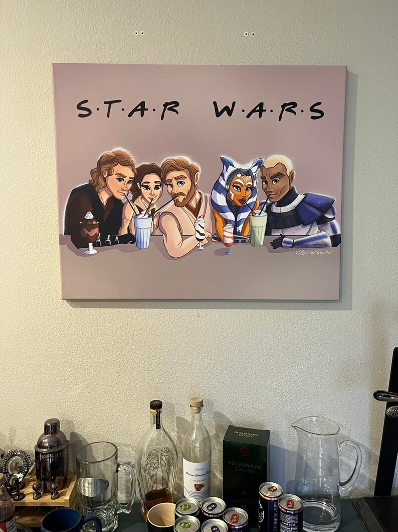 Peut inclure: Une impression encadr&eacute;e d'une illustration de bande dessin&eacute;e de six personnages de Star Wars assis &agrave; un comptoir en train de boire des laits frapp&eacute;s. Le titre de l'impression est "S.T.A.R. W.A.R.S."