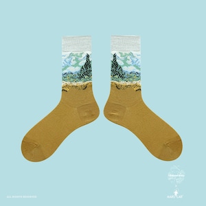 May include: A pair of mustard-colored socks with a landscape design featuring a tree, sky, and land. The top of the socks is gray. The socks are on a light blue background. The socks have the text "ALL RIGHTS RESERVED" and a logo.