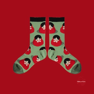 May include: A pair of green socks with a repeating pattern of red and white cartoon faces. The socks have black cuffs.