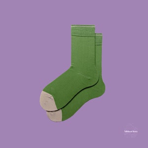 May include: A pair of green socks with a white trim. The socks are folded together and the toes are visible.