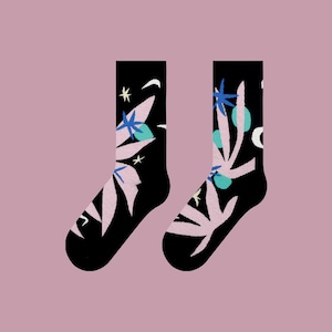 May include: A pair of black socks with a pink, blue, and green floral pattern. The socks have a white star design.
