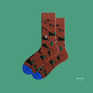 May include: A pair of brown socks with a geometric pattern in green and white. The socks have blue heels and toes.