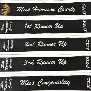 Op de afbeelding: Vijf zwart-witte sjerpen met witte tekst. De sjerpen lezen "Miss Harrison County", "1e Runner Up", "2e Runner Up", "3e Runner Up" en "Miss Congeniality". Het jaar 2025 is op elke sjerp gedrukt.