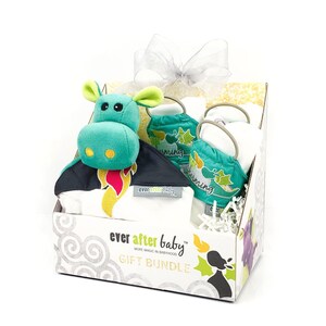 May include: A gift bundle for a baby featuring a green and black dragon plush toy, a white onesie with a dragon design, and two burp cloths with a green and white star design. The box is labeled "ever after baby" and "gift bundle".