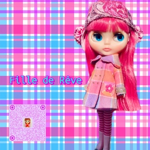 May include: A pink and white plaid doll with pink hair, wearing a pink and white plaid coat, a pink and white striped hat, and pink and white striped leggings. The doll is standing on a pink and blue plaid background. The text "Fille de R&ecirc;ve" is written in pink letters on the background.