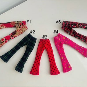 May include: Five pairs of bell bottom pants in various colors and patterns. The pants are numbered 1 through 5.  #1 is red and gold, #2 is green and black plaid, #3 is red with white polka dots, #4 is pink with gold and blue circles, and #5 is black with red and white geometric shapes.