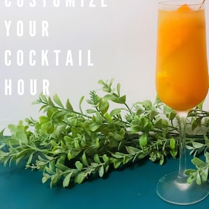 May include: A glass of orange juice with a red and white striped cocktail stick. The text "CUSTOMIZE YOUR COCKTAIL HOUR" is visible in the background.