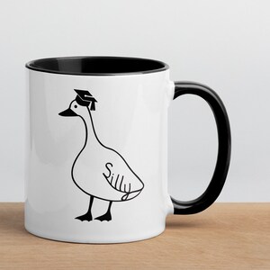 graduation era silly goose 2 tone mug black and white ceramic mug with graphic printed on both sides.