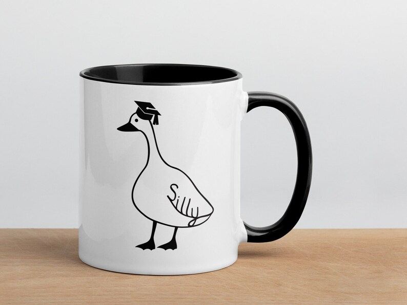 graduation era silly goose 2 tone mug black and white ceramic mug with graphic printed on both sides.
