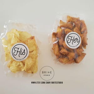 May include: Two clear plastic bags filled with snacks. One bag contains potato chips with a white sticker that says "His Favorite". The other bag contains pretzels with a white sticker that says "Her Favorite".
