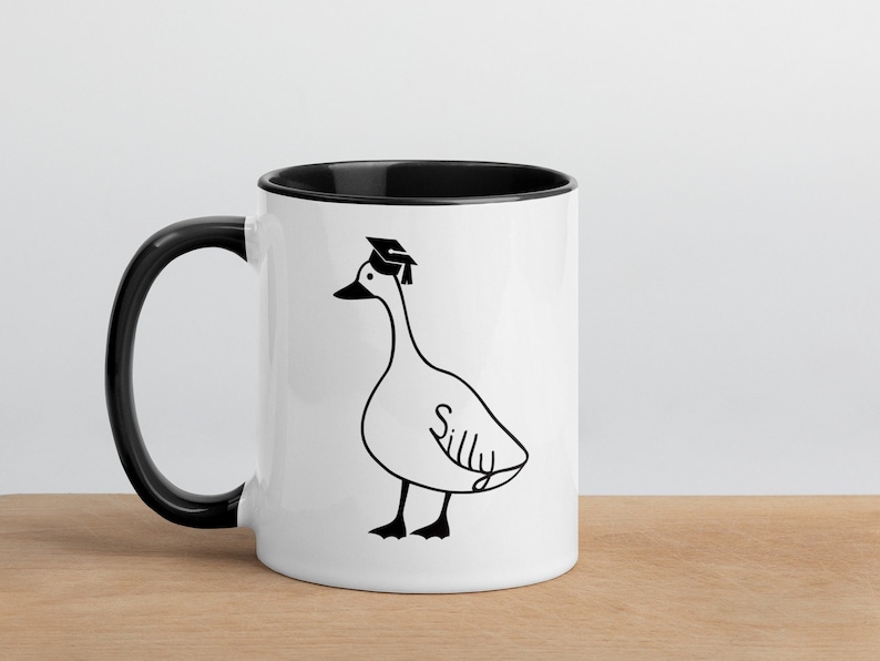 graduation era silly goose 2 tone mug black and white ceramic mug with graphic printed on both sides.