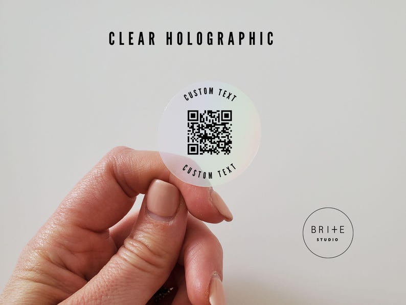 custom text 2 inch clear holographic qr code sticker shown against white background.