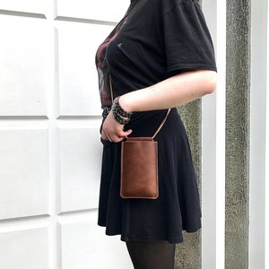 Bolso para llevar al hombro para el móvil fabricado en piel vintage marrón, con compartimento para dinero. Bolso bandolera de piel para smartphone en color marrón. Diseño minimalista.