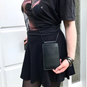 Bolso para móvil para colgar al hombro fabricado en piel vintage negra, con compartimento para dinero. Bolso bandolera pequeño de piel para smartphone. Diseño minimalista.