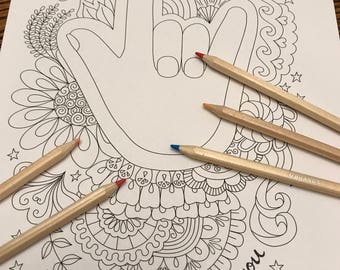 Peut inclure: Une page à colorier en noir et blanc représentant une main faisant le signe de la langue des signes 'Je t'aime'. La main est entourée de motifs floraux complexes et les mots 'Je t'aime' sont écrits en bas de la page.