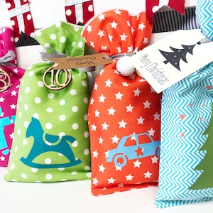 Calendario de adviento para que los niños rellenen de tela, bolsitas en rosa, verde, azul y naranja