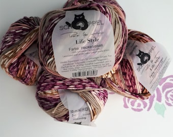 May include: Four balls of Schoppel Life Style yarn in the color Heckenrosen, featuring a variegated blend of magenta, tan, and white. Each ball has a paper label with a black cat logo, text, and technical specifications including 155m=50g.