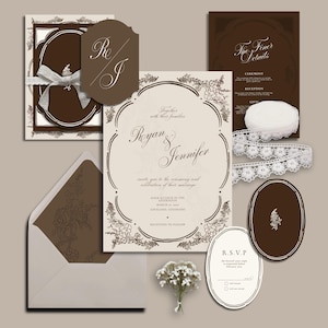 May include: A collection of wedding stationery in cream and brown. The set includes invitation cards, RSVP cards, and details cards, all with floral designs. Features a ribbon, lace trim, and a small bouquet of white flowers.