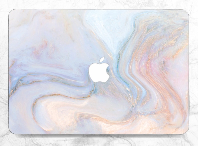 Puede incluir: Una piel para port&aacute;til con un patr&oacute;n de m&aacute;rmol en espiral en tonos de azul claro, rosa y dorado. El logotipo de Apple es visible en el centro de la piel.