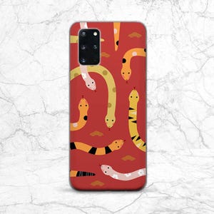 May include: Red phone case featuring a pattern of yellow, orange and black snakes. The case has a cut-out for the camera lens.