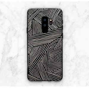 K&ouml;nnte beinhalten: Schwarze Handyh&uuml;lle mit einem wei&szlig;en geometrischen Muster aus sich kreuzenden Linien.