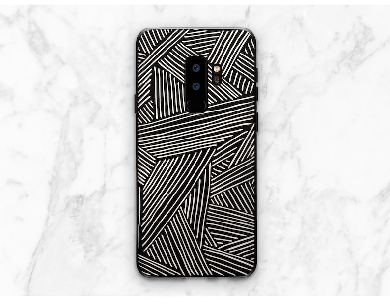 K&ouml;nnte beinhalten: Schwarze Handyh&uuml;lle mit einem wei&szlig;en geometrischen Muster aus sich kreuzenden Linien.