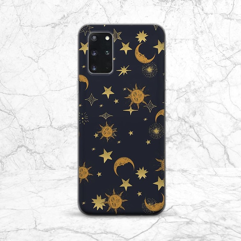 May include: A black phone case with a gold celestial pattern. The pattern includes stars, moons, and suns.