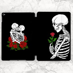 May include: Two skeletons embracing with red roses, and a single skeleton holding a red rose on a black background.
