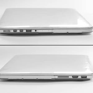 K&ouml;nnte beinhalten: Zwei silberne Laptops werden vor wei&szlig;em Hintergrund &uuml;bereinander dargestellt. Die Laptops sind geschlossen und zeigen ihr schlankes, minimalistisches Design. Die Seitenprofile zeigen Anschl&uuml;sse f&uuml;r die Konnektivit&auml;t, einschlie&szlig;lich USB und Audiobuchsen.
