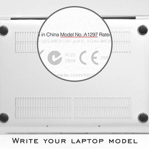 May include: Close-up of the bottom of a silver laptop with the text "in China Model No.: A1297 Rate" visible. The laptop has a silver finish and a black rubber strip around the edge.