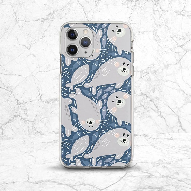 May include: A clear phone case with a pattern of gray seals and blue fish on a blue background.