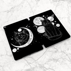 May include: Black and white illustration of two black cats with crescent moons and stars on a black background. The cats are surrounded by planets and stars.