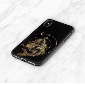 May include: Black phone case with a gold mermaid design and a crescent moon and stars.