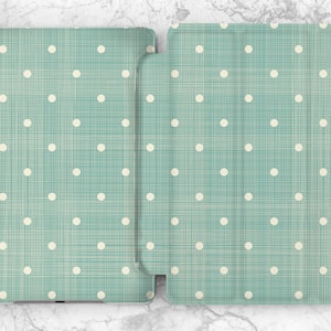 May include: A teal blue iPad case with a white polka dot pattern and a subtle woven texture.