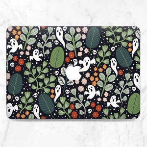 May include: A black laptop case featuring a repeating pattern of white ghosts, small skulls, and various floral and leaf elements in shades of green, orange, and pink. The case has a glossy finish.