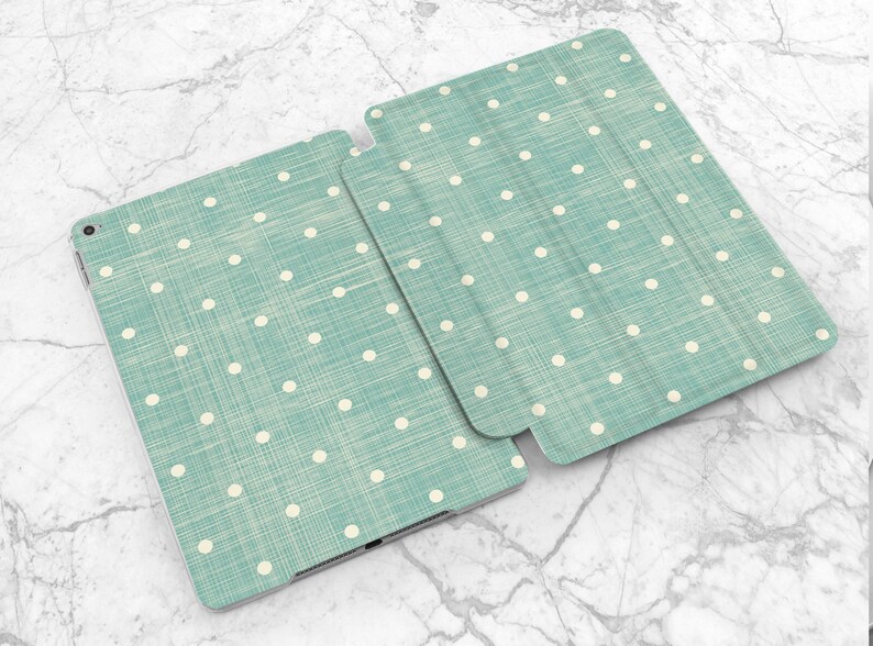 May include: A teal blue iPad case with a white polka dot pattern. The case has a linen texture.
